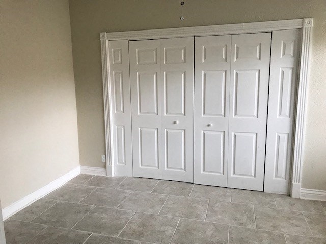 an empty room with two closets and a tile floor