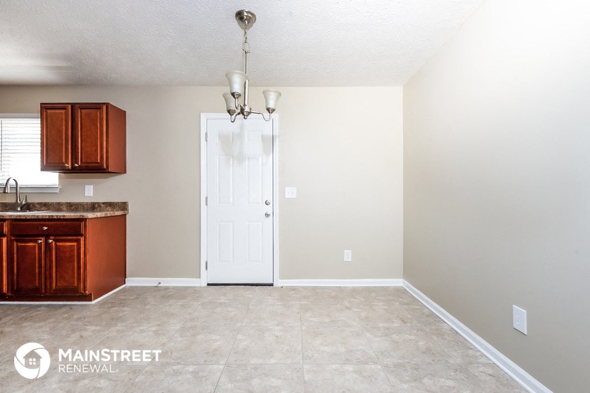 an empty kitchen with a white door and a counter top