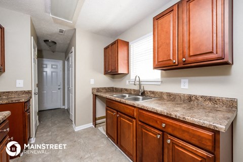 a kitchen with wooden cabinets and granite counter tops and a sink