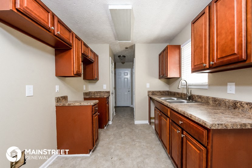 a kitchen with wooden cabinets and granite counter tops and a sink