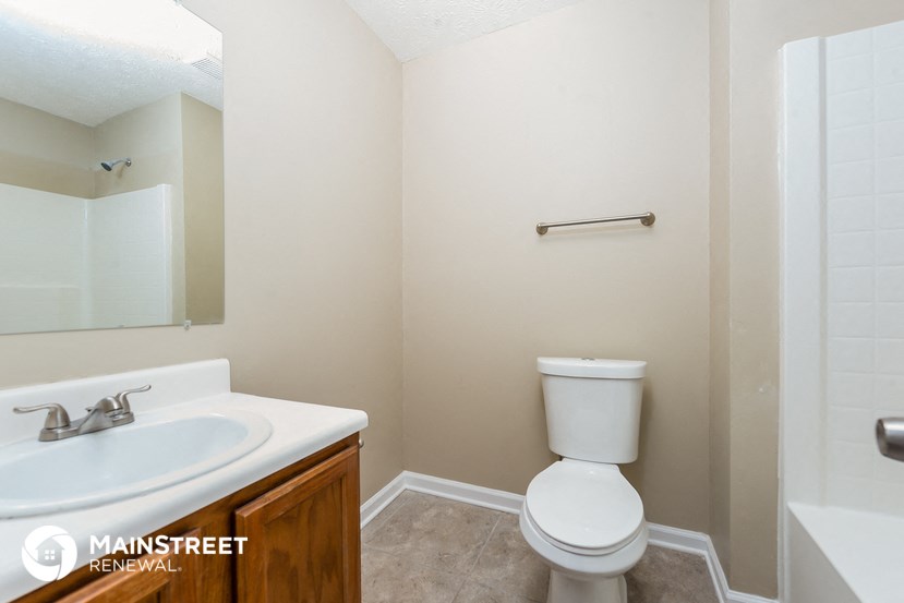 a bathroom with a toilet and a sink and a mirror