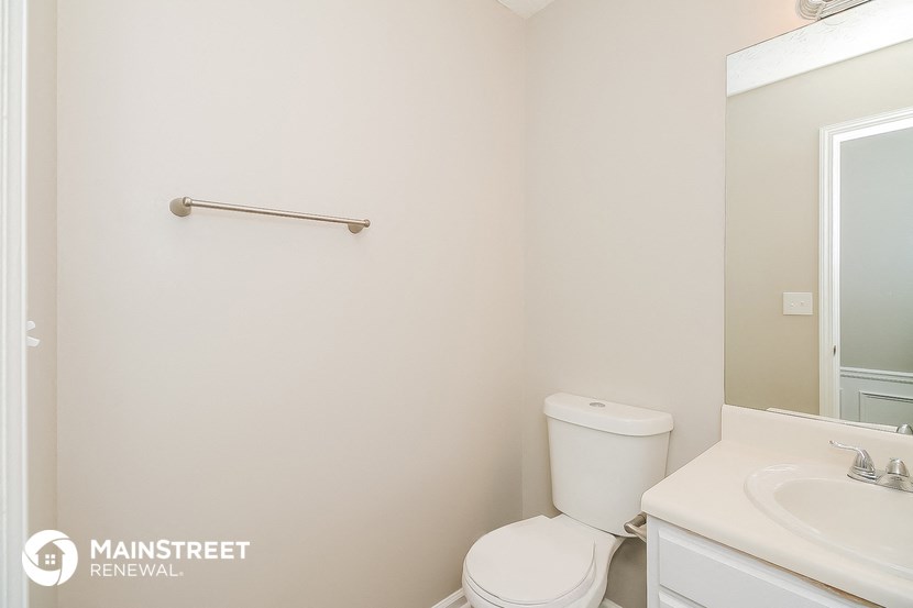 a bathroom with a toilet and a sink and a mirror