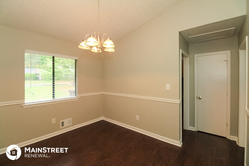 the interior of a small room with wood flooring and a window