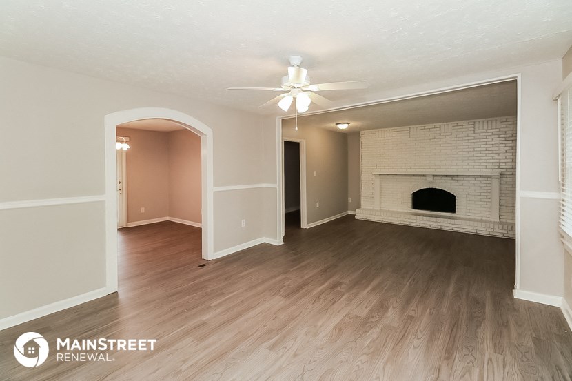 a living room with a fireplace and a ceiling fan