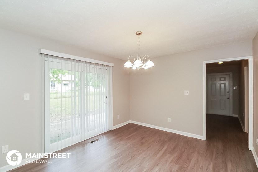 an empty living room with wood flooring and a large window