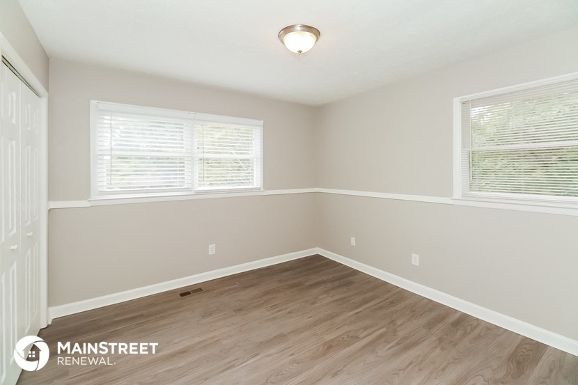 the spacious dining room with hardwood flooring and two windows