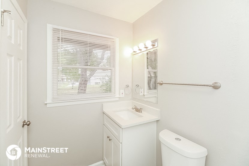 a bathroom with a sink toilet and a window
