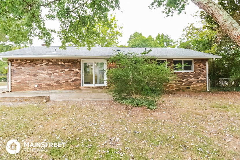 a small brick house with a tree in front of it