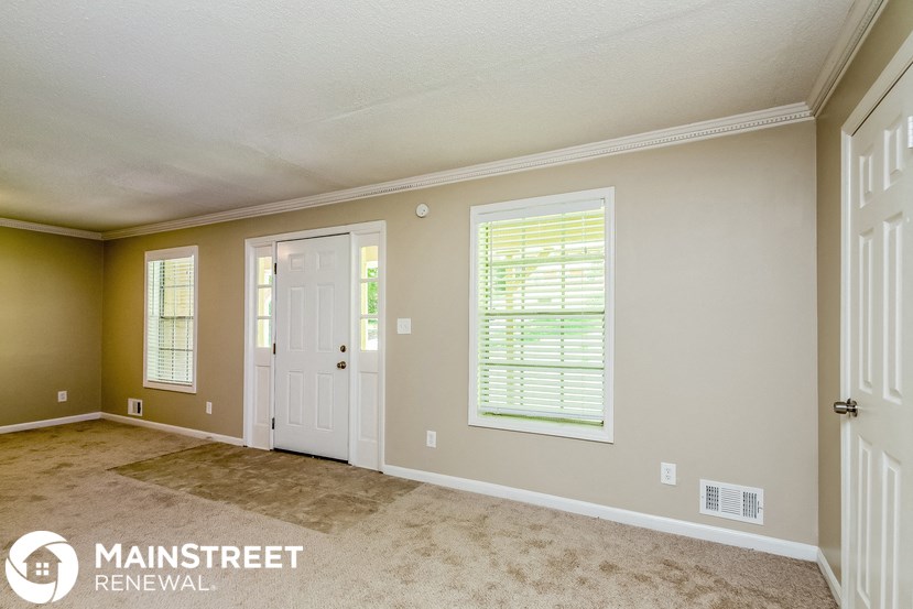a living room with beige walls and a white door