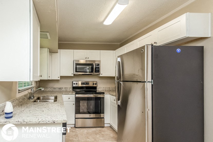a kitchen with stainless steel appliances and white cabinets