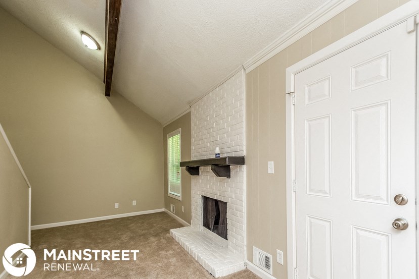 a living room with a fireplace and a white door