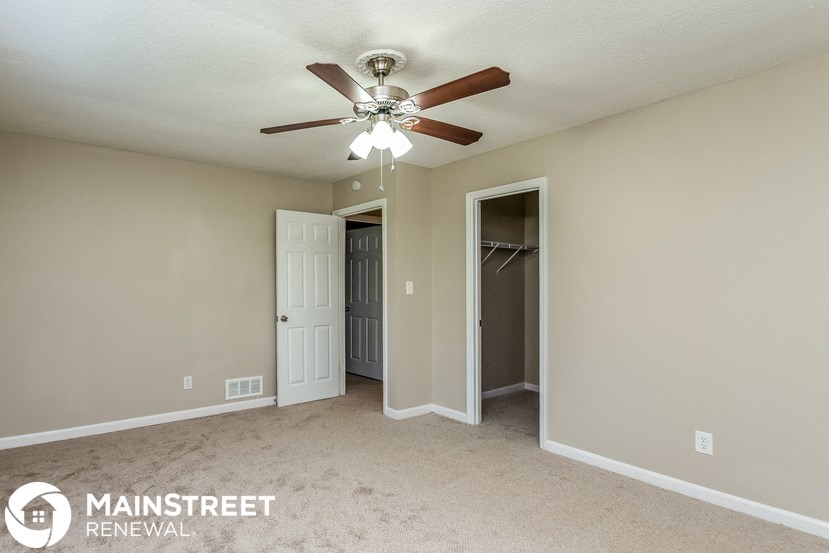 a bedroom with a ceiling fan and a closet