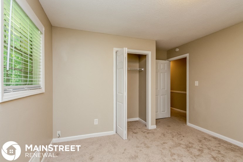 a bedroom with a closet and a window and an open door