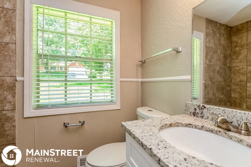 a bathroom with a sink toilet and a window