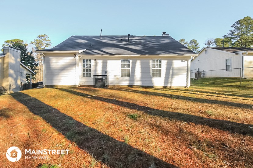 the front yard of a white house with a gray roof