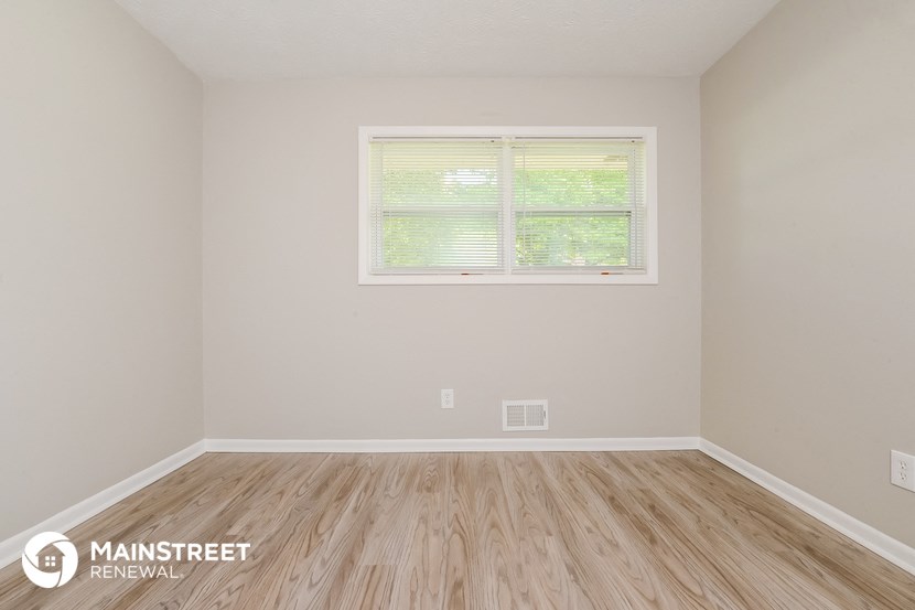 the interior of an empty room with wooden floors and a window