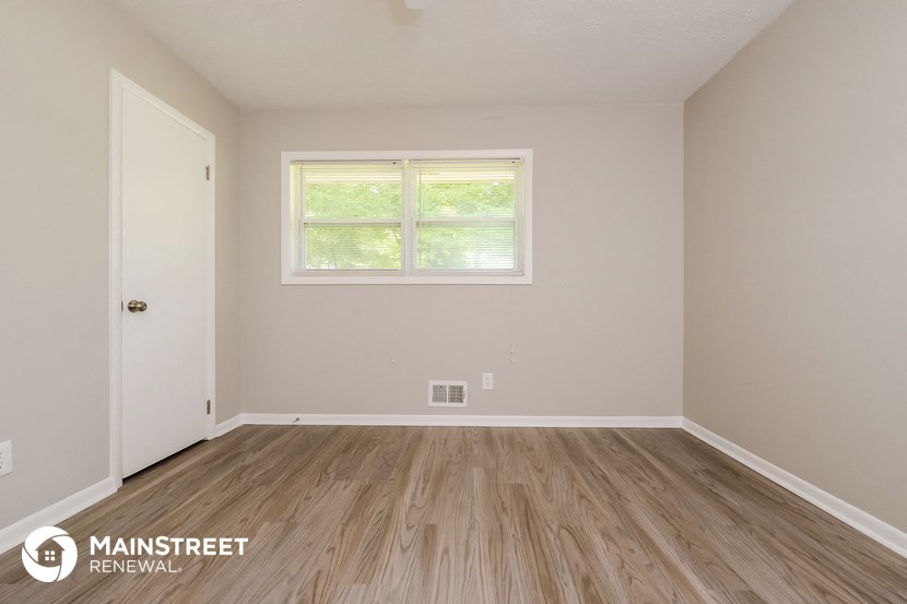 the interior of an empty room with wooden floors and a window
