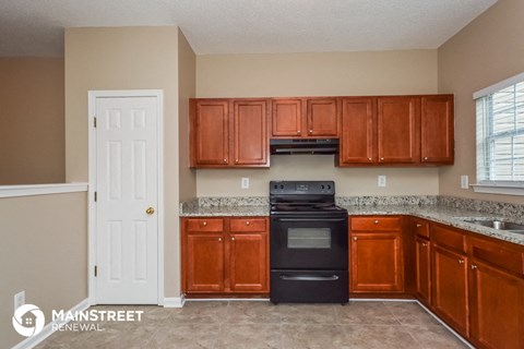 a kitchen with wooden cabinets and a black stove and refrigerator