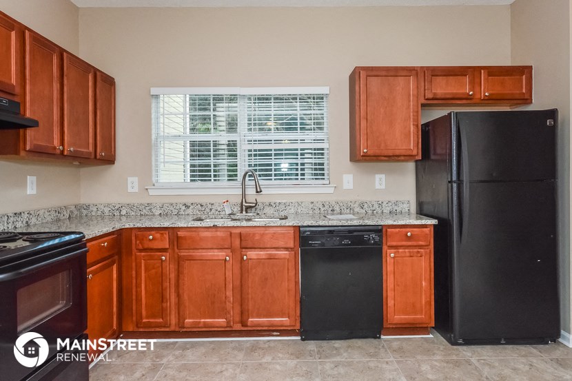a kitchen with wooden cabinets and a black refrigerator