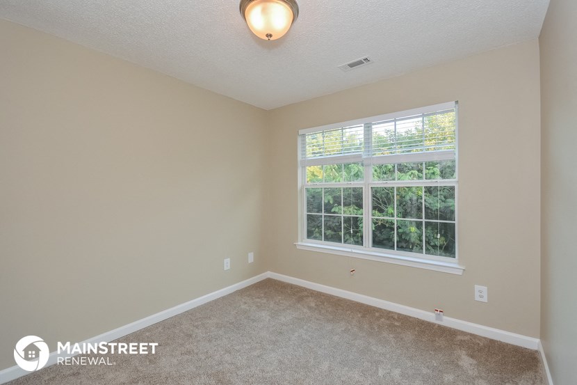 the upstairs bedroom with carpet and a large window
