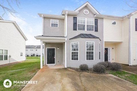 a white house with black windows and a driveway