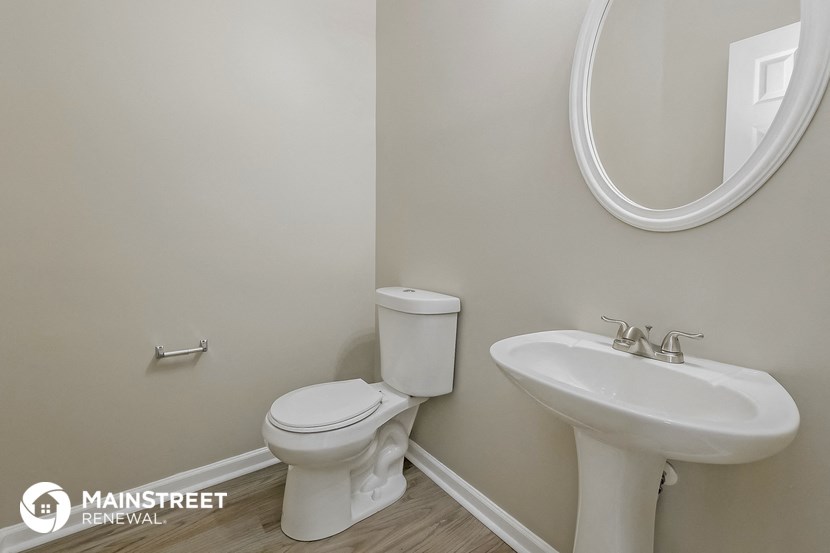 a bathroom with a toilet sink and a mirror
