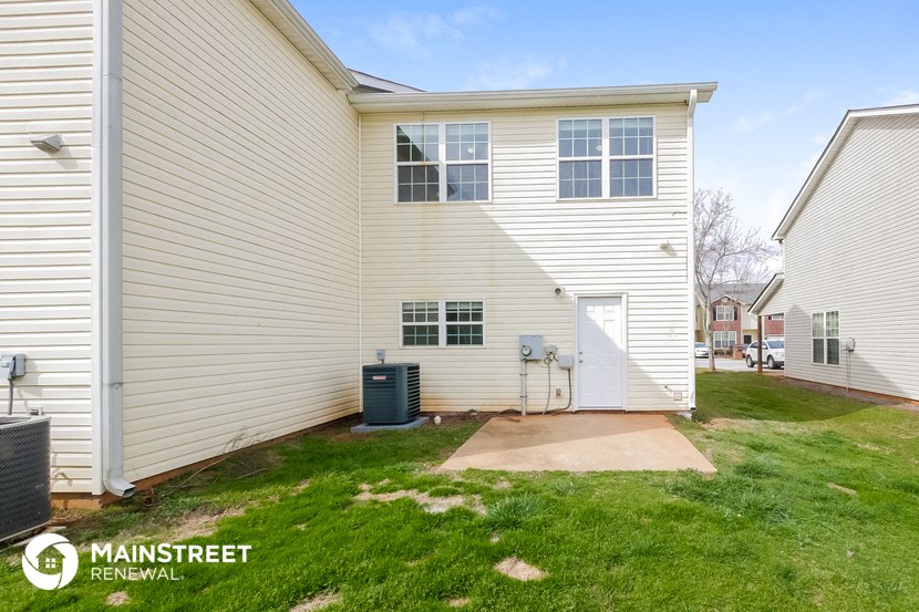 a white house with a yard and a backdoor