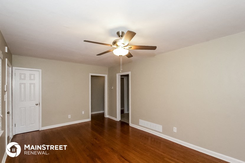 a living room with wood floors and a ceiling fan