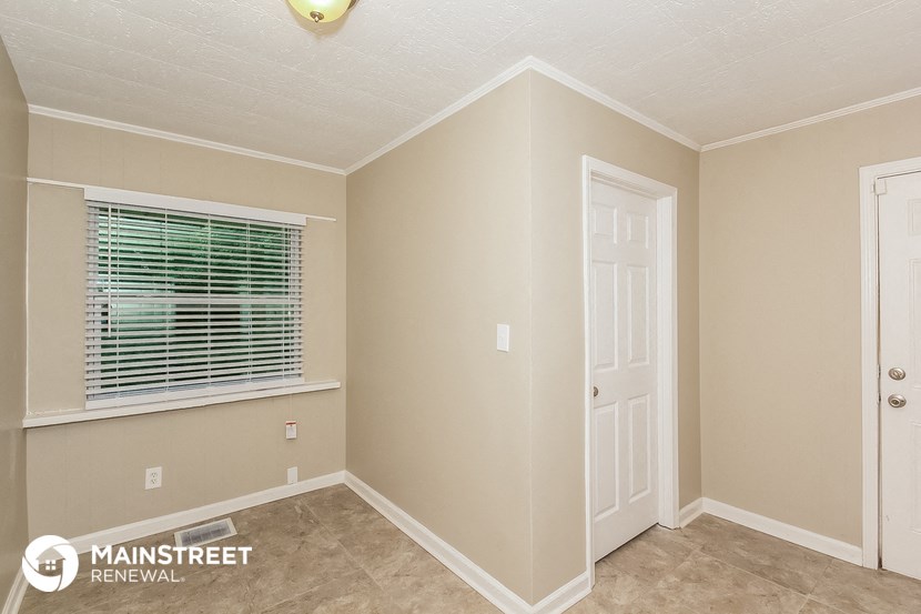 a bedroom with a window and a white door