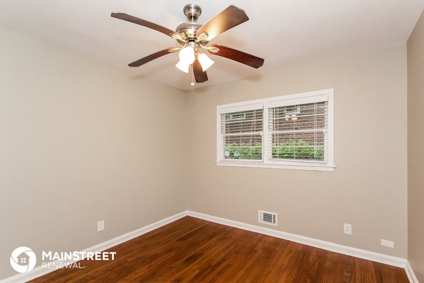 the master bedroom has a ceiling fan and hardwood floors