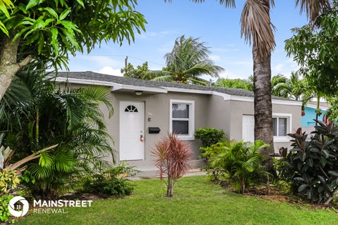 a small with a white door and palm trees