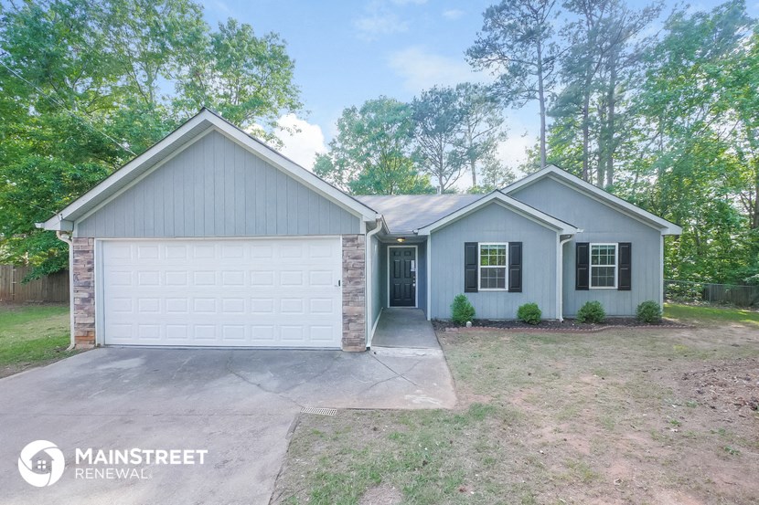 a renovated home with a white garage door and a driveway