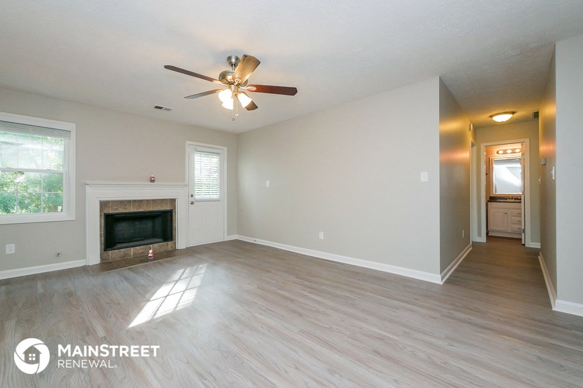 the living room with fireplace and ceiling fan