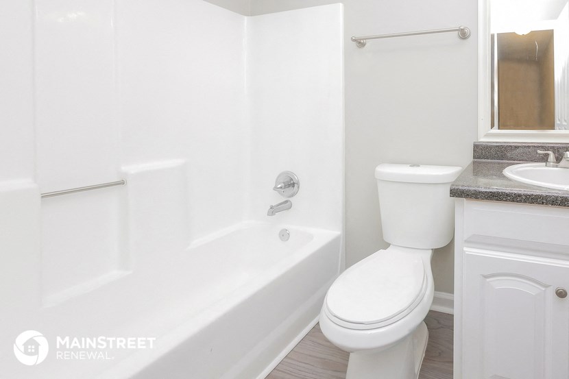 a bathroom with a toilet and a tub and a sink