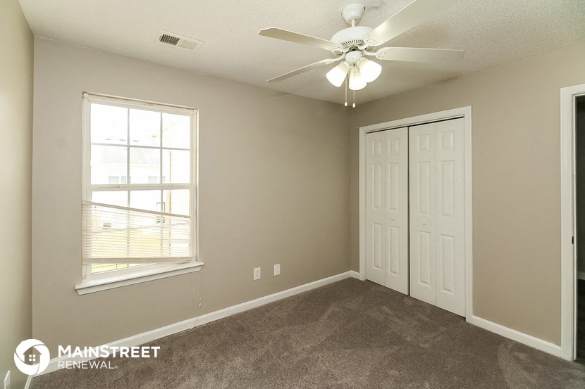 the living room of a home with a ceiling fan and a window
