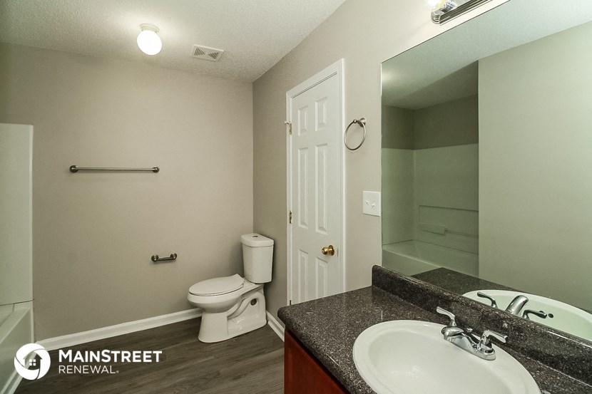 a bathroom with a sink and a toilet and a mirror