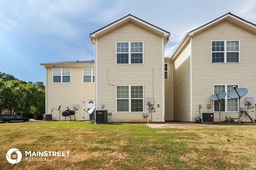 a side view of a house with a yard in front of it