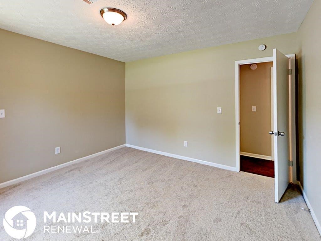 an empty living room with a door to a closet