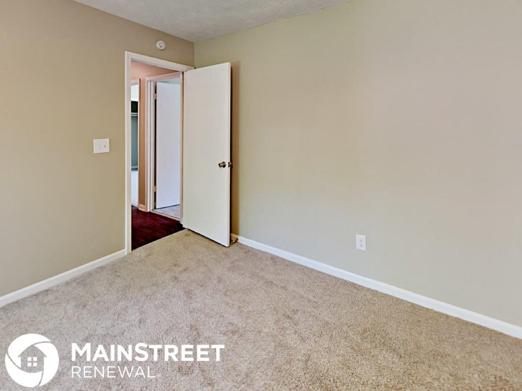 a bedroom with a carpeted floor and an open door