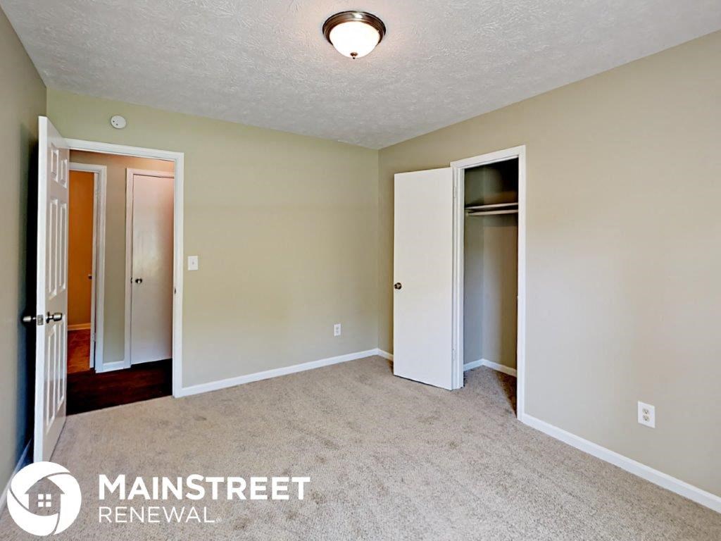 a bedroom with a carpeted floor and a door to a closet
