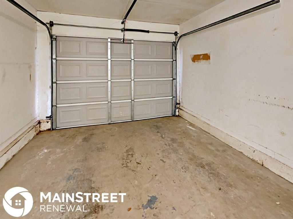 the inside of a garage with white walls and a concrete floor