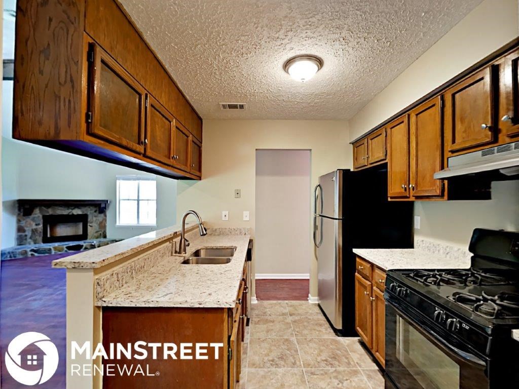 a kitchen with a sink and a stove and a refrigerator
