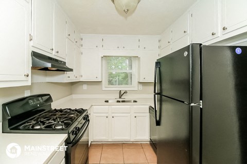 a kitchen with black appliances and white cabinets
