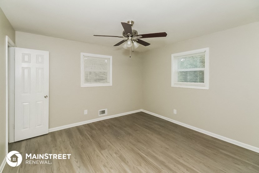 the interior of an empty room with a ceiling fan