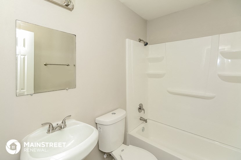 a white bathroom with a white sink and toilet and a tub