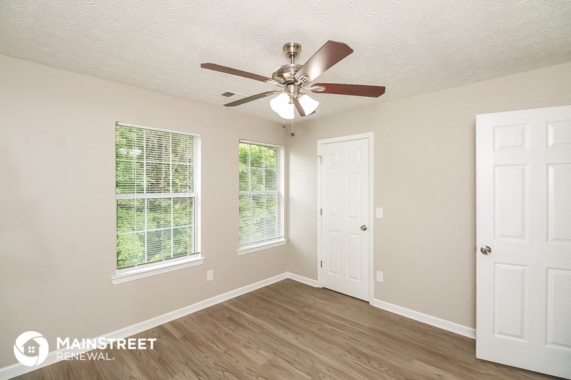 a bedroom with a ceiling fan and a door
