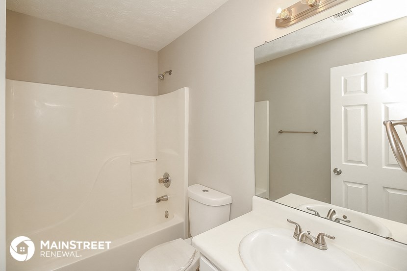 a bathroom with a sink and a tub and a mirror