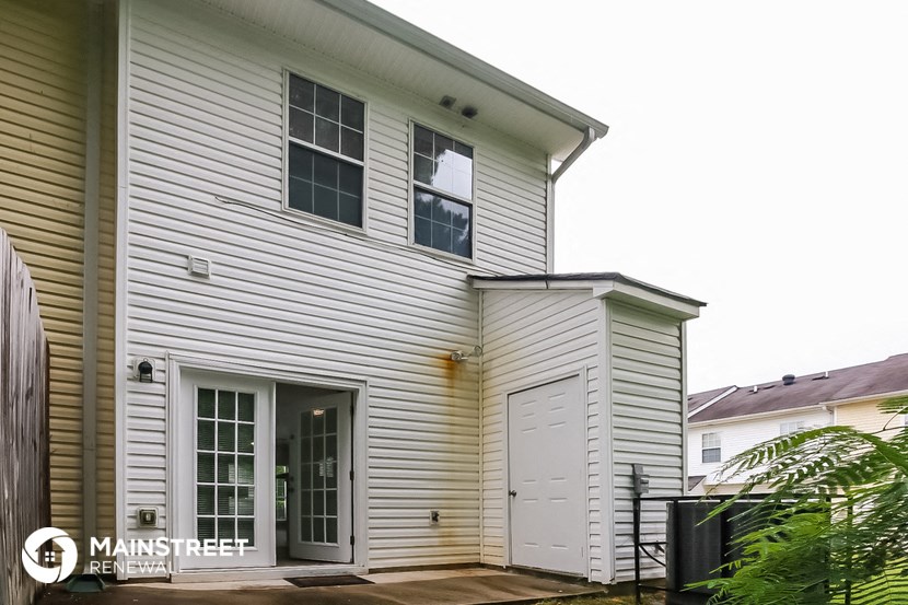 the outside of a white house with white siding and a garage door