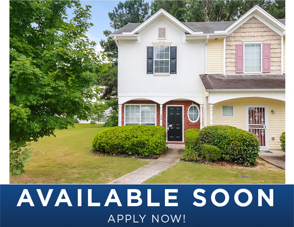 a white house with a lawn and a tree