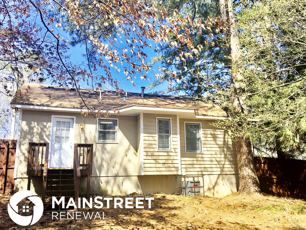 a small house with a tree in front of it